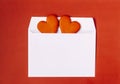 Two cookies in the shape of heart in a white envelope on red background Royalty Free Stock Photo