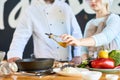 Two Cooks Adding Olive Oil to Dish Close up