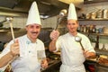 Two cooks with spoons and ladles in them hands