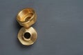 Two copper or bronze fitting with thread for small and big pipe lies on dark concrete table in workshop