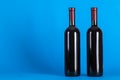 Two corked bottles of wine on a blue background. Wine drinking culture concept. Space for text Royalty Free Stock Photo