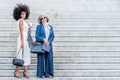 two corporate women smiling and posing well-dressed