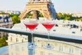 Two Cosmopolitan cocktails in traditional martini glasses with view to the Eiffel tower, Paris, France