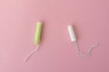 Two cotton tampons with light green applicator and without applicator on a pink background. Hygienic types of tampons. Royalty Free Stock Photo