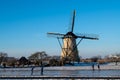 Two couple of ice skater on a frozen windmill canal at sunrise moment