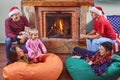 Two couples celebrate Christmas near the fireplace