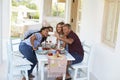 Two couples at dinner on a patio leaning in for a selfie Royalty Free Stock Photo