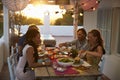 Two couples eating dinner at a table on a rooftop terrace Royalty Free Stock Photo