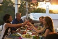 Two couples making a toast at dinner on a rooftop terrace Royalty Free Stock Photo
