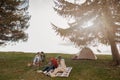 Two couples resting and having fun on top of mountain at tent. Camping concept. Royalty Free Stock Photo