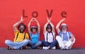 Two couples, senior and middle aged, trying to write the word love with hands. dressed with colorful suspenders, bow ties and