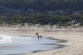 Two couples walk on a beach. Fingal Bay. Australi