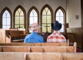 Two cowboys sitting together in a church pew. Royalty Free Stock Photo