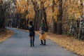 Two cozy smiling young girls walk at autumn park road Royalty Free Stock Photo