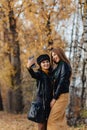 two cozy young girls walk at autumn park road an make photos Royalty Free Stock Photo