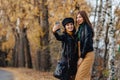 two cozy young girls walk at autumn park road an make photos Royalty Free Stock Photo