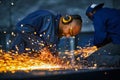 Two craftsmen in protective uniform welding metal Royalty Free Stock Photo