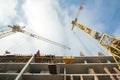 Two cranes and building under construction against the sky Royalty Free Stock Photo