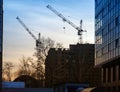 Two cranes raised their arrows over the unfinished multi-story building