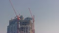 Two cranes working on constraction site works of new skyscraper timelapse Royalty Free Stock Photo
