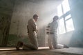 Two crazy men in straitjackets are in an abandoned clinic