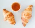 Two crispy French breakfast croissants with a jam