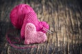 Two crochet pink hearts on wooden background