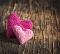 Two crochet pink hearts on wooden background