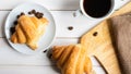 two croissants and a cup of coffee on a white wooden table Royalty Free Stock Photo
