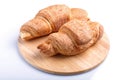 Two croissants on wooden kitchen board isolated on white background Royalty Free Stock Photo