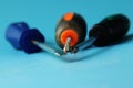 A two cross-point screwdrivers, one with black handle, second with orange-grey grip. Third tool is flat screwdriver Royalty Free Stock Photo