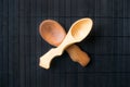 Two crossed empty handmade wooden spoons from different wood and