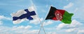 two crossed flags Afghanistan and finland waving in wind at cloudy sky. Concept of relationship, dialog, travelling between two