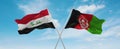 two crossed flags Afghanistan and Iraq waving in wind at cloudy sky. Concept of relationship, dialog, travelling between two