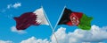 two crossed flags Afghanistan and Qatar waving in wind at cloudy sky. Concept of relationship, dialog, travelling between two