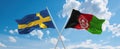 two crossed flags Afghanistan and Sweden waving in wind at cloudy sky. Concept of relationship, dialog, travelling between two