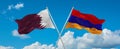 two crossed flags Armenia and Qatar waving in wind at cloudy sky. Concept of relationship, dialog, travelling between two