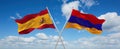 two crossed flags Armenia and spain waving in wind at cloudy sky. Concept of relationship, dialog, travelling between two