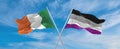 two crossed flags asexuality Pride and Ireland waving in wind at cloudy sky. Concept of relationship, dialog, travelling between