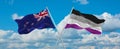 two crossed flags asexuality Pride and New Zealand waving in wind at cloudy sky. Concept of relationship, dialog, travelling