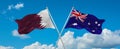 two crossed flags Australia and Qatar waving in wind at cloudy sky. Concept of relationship, dialog, travelling between two