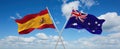 two crossed flags Australia and spain waving in wind at cloudy sky. Concept of relationship, dialog, travelling between two