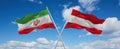two crossed flags Austria and Iran waving in wind at cloudy sky. Concept of relationship, dialog, travelling between two