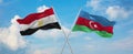 two crossed flags Azerbaijan and Egypt waving in wind at cloudy sky. Concept of relationship, dialog, travelling between two