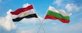 two crossed flags Bulgaria and Egypt waving in wind at cloudy sky. Concept of relationship, dialog, travelling between two