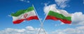 two crossed flags Bulgaria and Iran waving in wind at cloudy sky. Concept of relationship, dialog, travelling between two