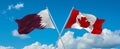 two crossed flags canada and Qatar waving in wind at cloudy sky. Concept of relationship, dialog, travelling between two countries