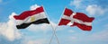 two crossed flags denmark and Egypt waving in wind at cloudy sky. Concept of relationship, dialog, travelling between two