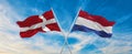 two crossed flags denmark and Netherland waving in wind at cloudy sky. Concept of relationship, dialog, travelling between two