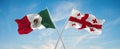 two crossed flags Georgia and mexico waving in wind at cloudy sky. Concept of relationship, dialog, travelling between two